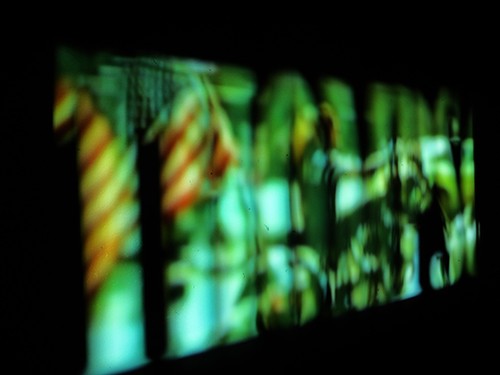Mit grünem Filmmaterial gefüllte Projektion der von Hunter Thompson inspirierten Schrift auf dunklem Hintergrund, unscharf
