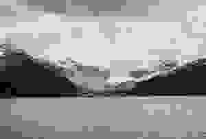 Kanadischer See vor Berglandschaft mit Schnee auf den Gipfeln