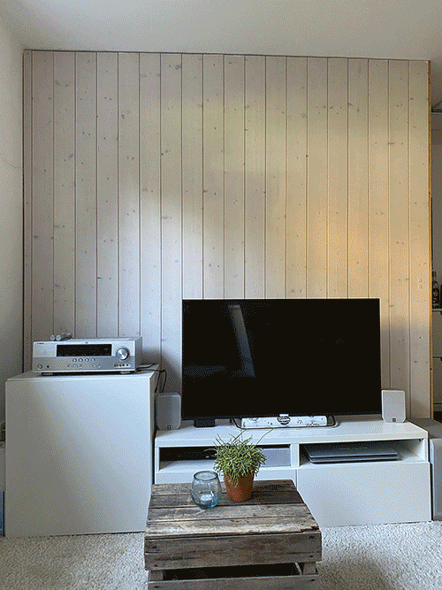 Bildersequenz vom Aufbau einer dunklen Holzwand hinter einem Fernseher